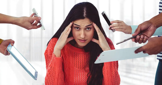 Stressed woman at workplace. Stress management techniques by Nutrigrams.